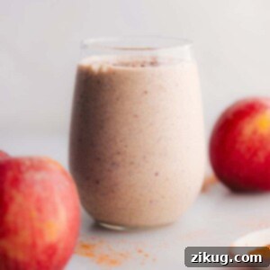 A freshly blended Protein Apple Smoothie in a glass, ready to be served, topped with cinnamon.