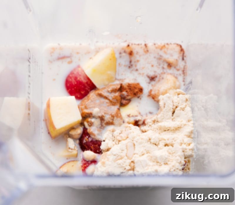 A high-speed blender full of all the combined ingredients for the Apple Smoothie, ready to be processed into a smooth, creamy drink.