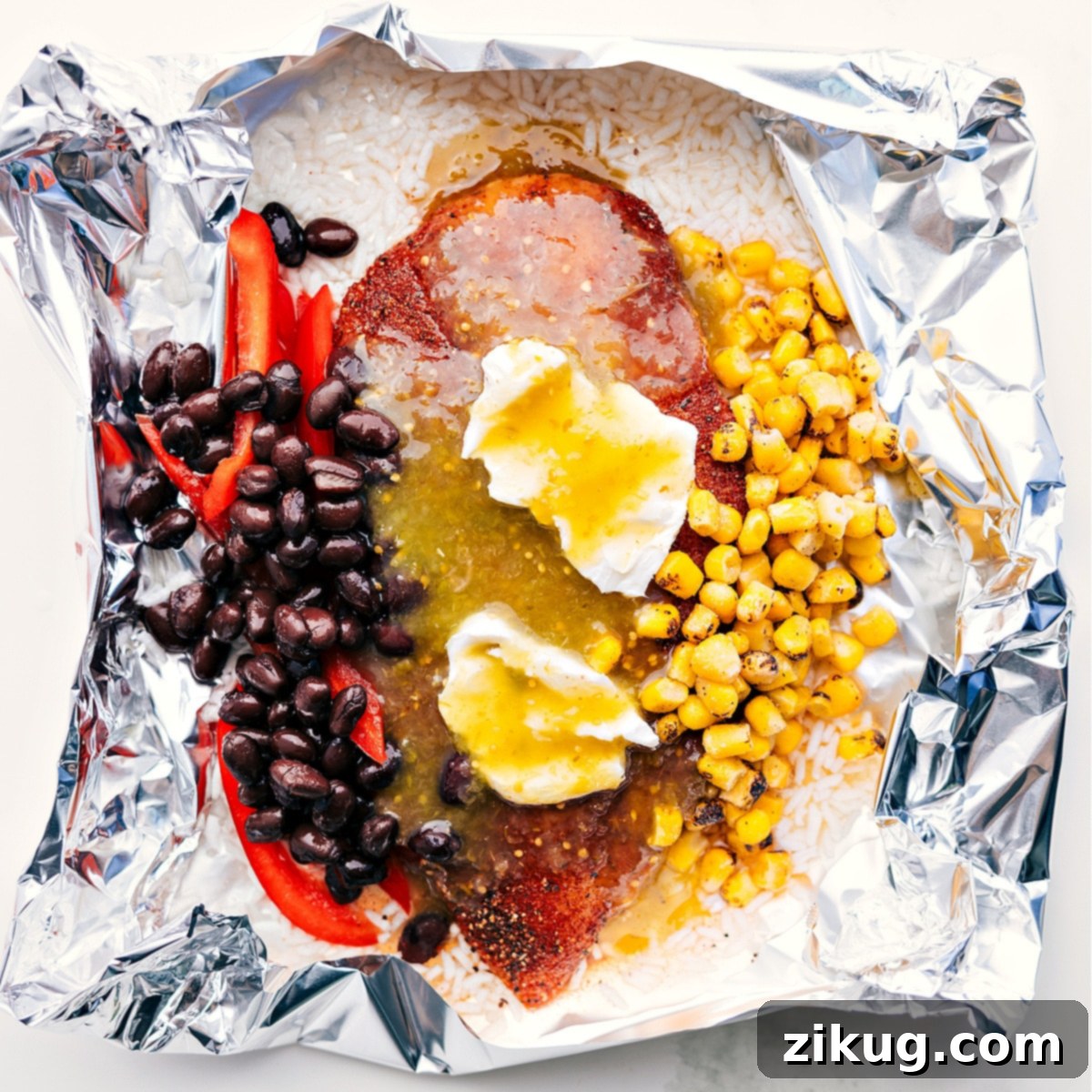 Flavorful And Delicious Chicken Rice Foil Packs Foil packet filled with rice, corn, beans, cream cheese, salsa verde, and chicken, ready to be cooked over a fire, grill, or in the oven. A complete and balanced meal in one package.
