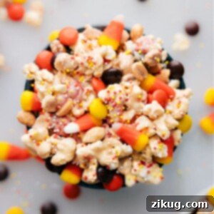 Finished Candy Corn Popcorn clusters in a rustic bowl, showcasing the white chocolate coating, colorful candy corn, and peanuts, ready for serving.