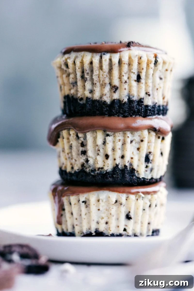 Oreo Cheesecake Bites 2 Three Mini Oreo Cheesecakes stacked on top of each other, showcasing their layers of Oreo crust, creamy filling, and glossy chocolate ganache.