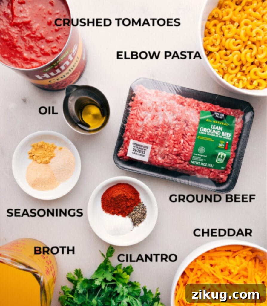 Fresh ingredients laid out for homemade Hamburger Helper dish, including ground beef, pasta, cheese, and spices.