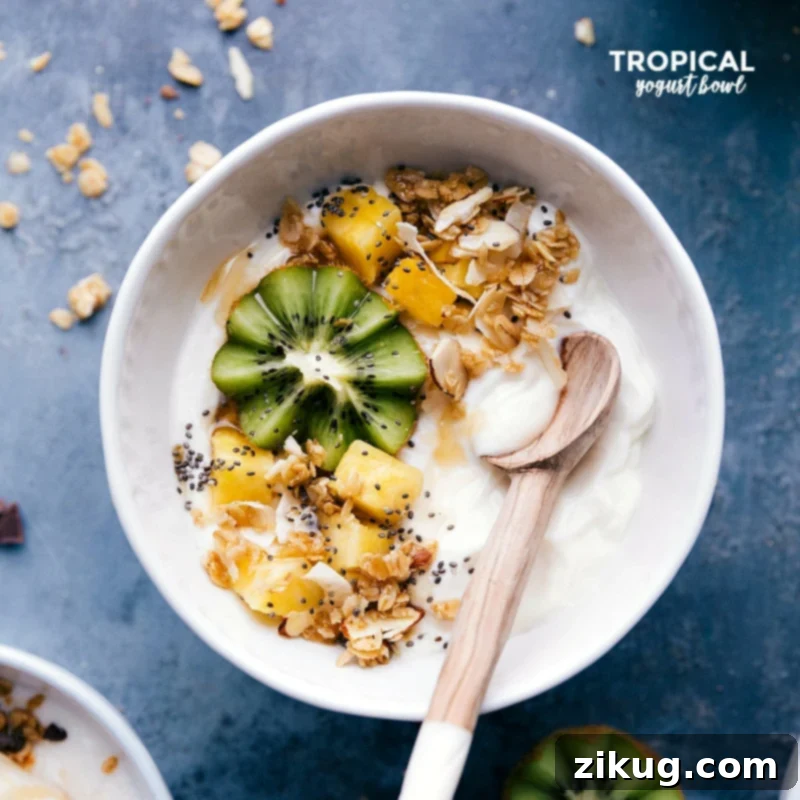 Yogurt bowl filled with fresh kiwi, pineapple, and a generous sprinkle of granola, evoking a sunny, refreshing feel.
