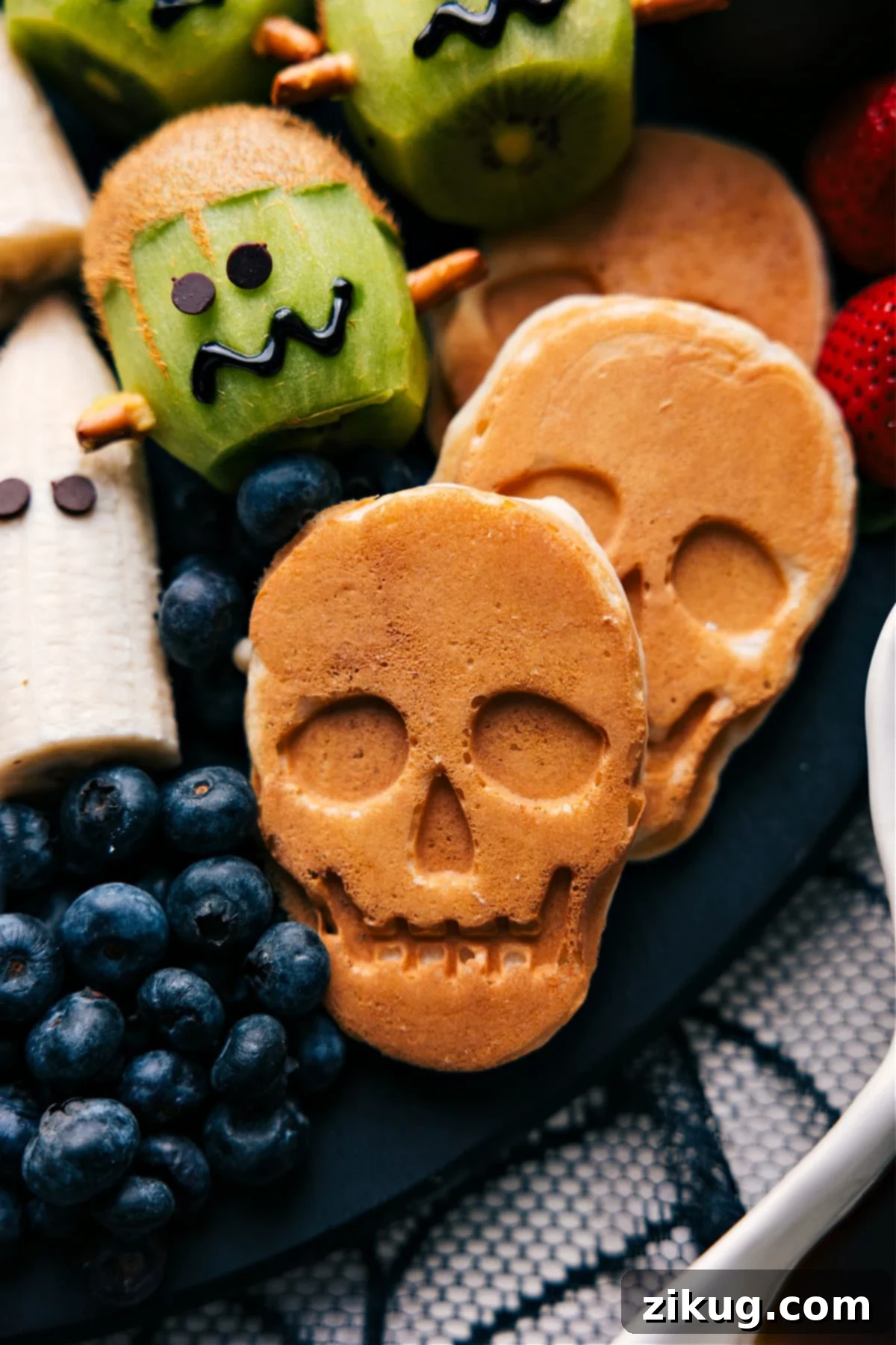 Delicious pancakes shaped like skulls, perfectly cooked and arranged on a serving plate, ready to be enjoyed as a spooky Halloween breakfast.