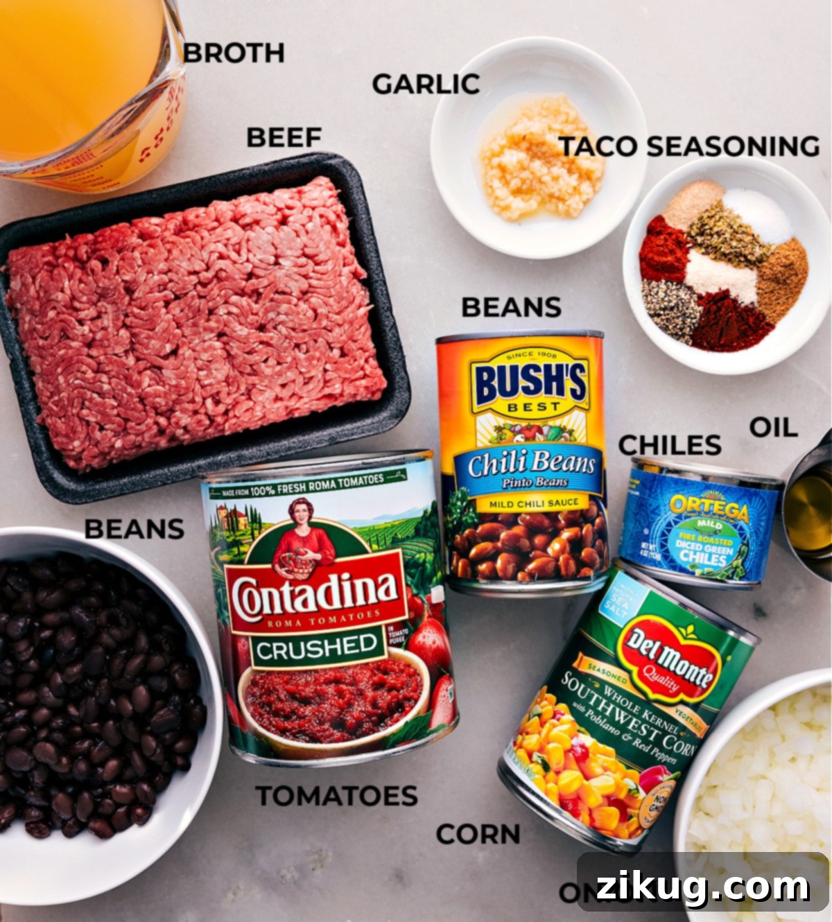 A colorful array of fresh and canned ingredients neatly arranged on a wooden board, showcasing everything needed for a delicious Taco Soup recipe. Includes ground beef, various beans, corn, diced tomatoes, broth, and a selection of vibrant spices.