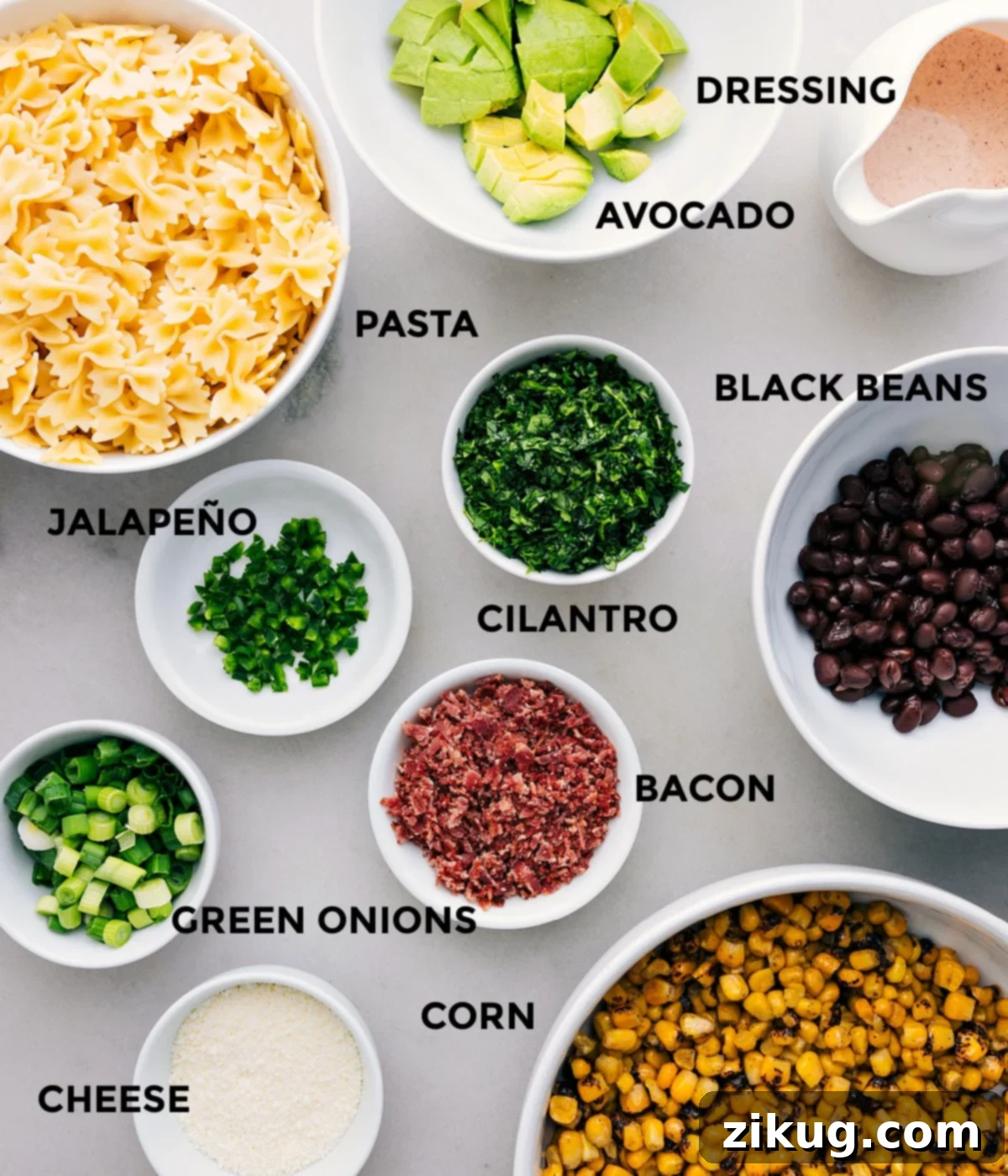 Fresh Ingredients for Mexican Street Corn Pasta Salad All the vibrant, fresh ingredients meticulously prepped and arranged for easy assembly of Mexican Street Corn Pasta Salad: a creamy dressing, diced avocado, rinsed black beans, fresh cilantro, cooked pasta, crispy bacon, thinly sliced green onions, charred corn kernels, and crumbled Cotija cheese.