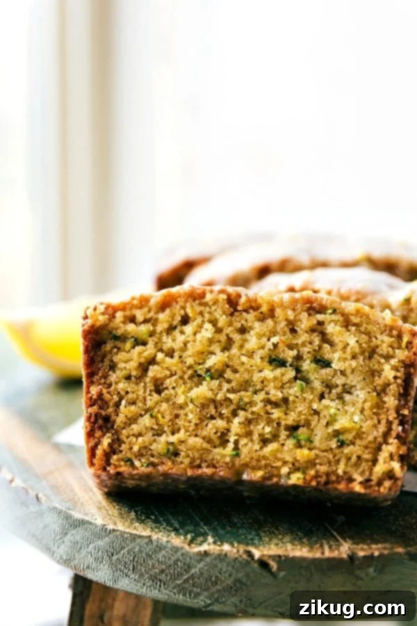 The delicious and flavorful lemon zucchini bread cut into slices, showing its moist texture and vibrant lemon glaze.