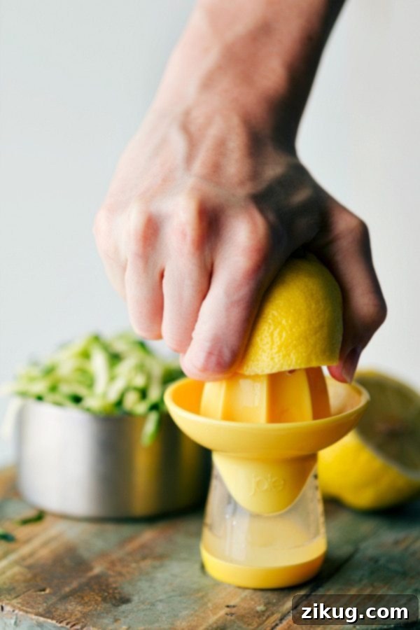 A vibrant yellow lemon being squeezed to extract fresh juice, highlighting the key citrus ingredient for the bread.