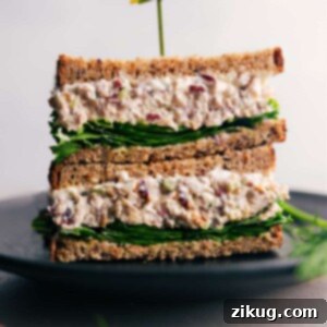 A perfectly assembled Turkey Salad sandwich, sliced in half, revealing generous layers of turkey salad and crisp lettuce, ready for a delicious bite.