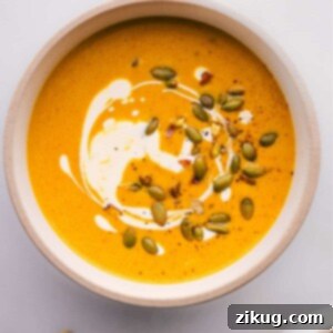 A bowl of pumpkin curry soup ready to be enjoyed, garnished with a swirl of cream.