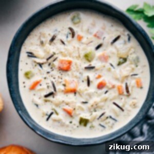 A comforting bowl of Creamy Chicken and Wild Rice Soup, garnished with fresh herbs.