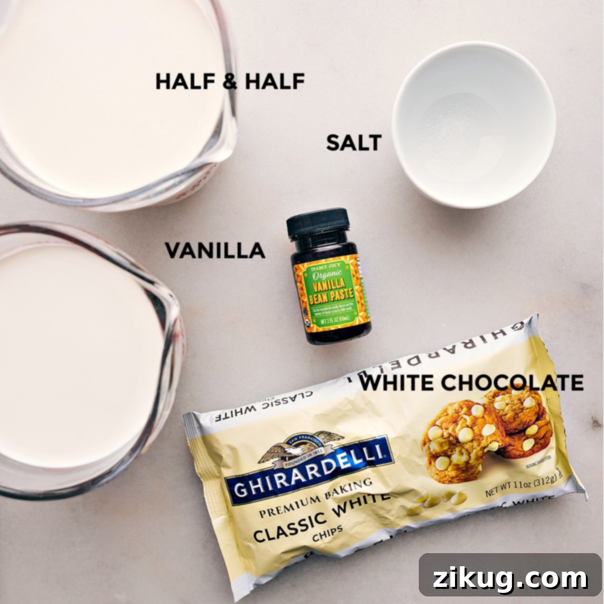 All the essential ingredients for making this delicious White Hot Chocolate laid out on a clean surface, including half-and-half, high-quality white chocolate chips, vanilla bean paste, and a pinch of salt.