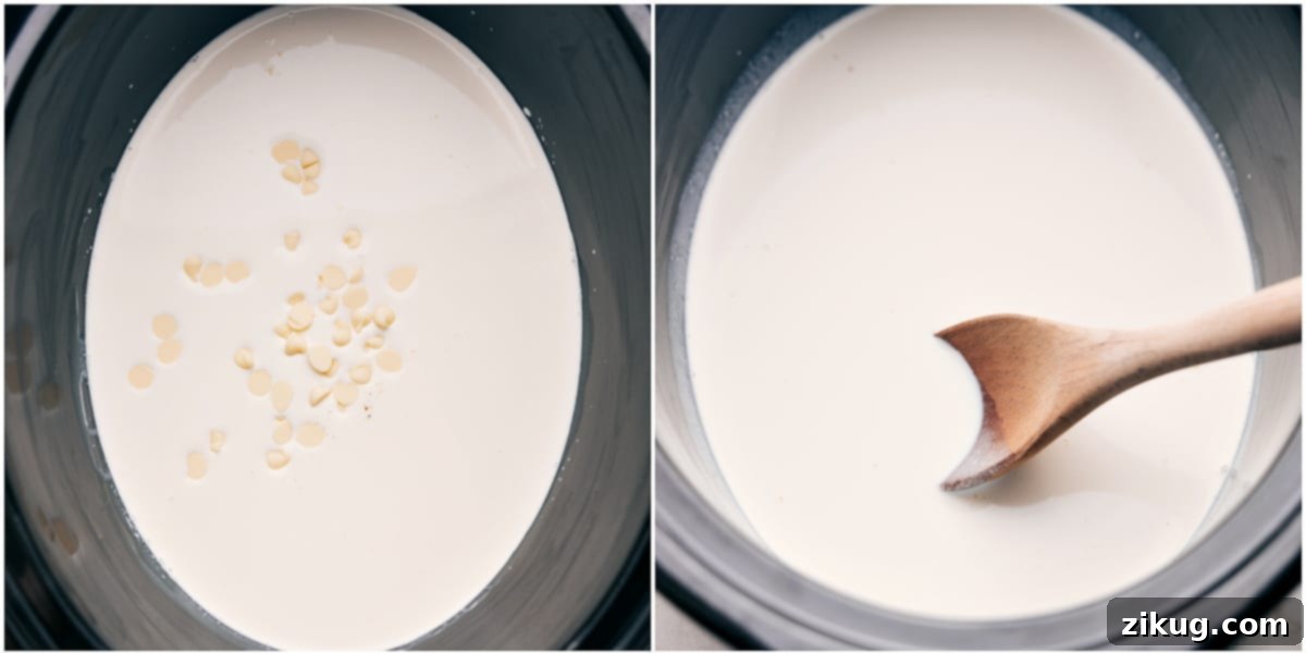 White chocolate chips being added to a pot of half-and-half, simmering gently on the stovetop. The mixture is being stirred continuously to ensure the chocolate melts until smooth for the hot chocolate preparation.