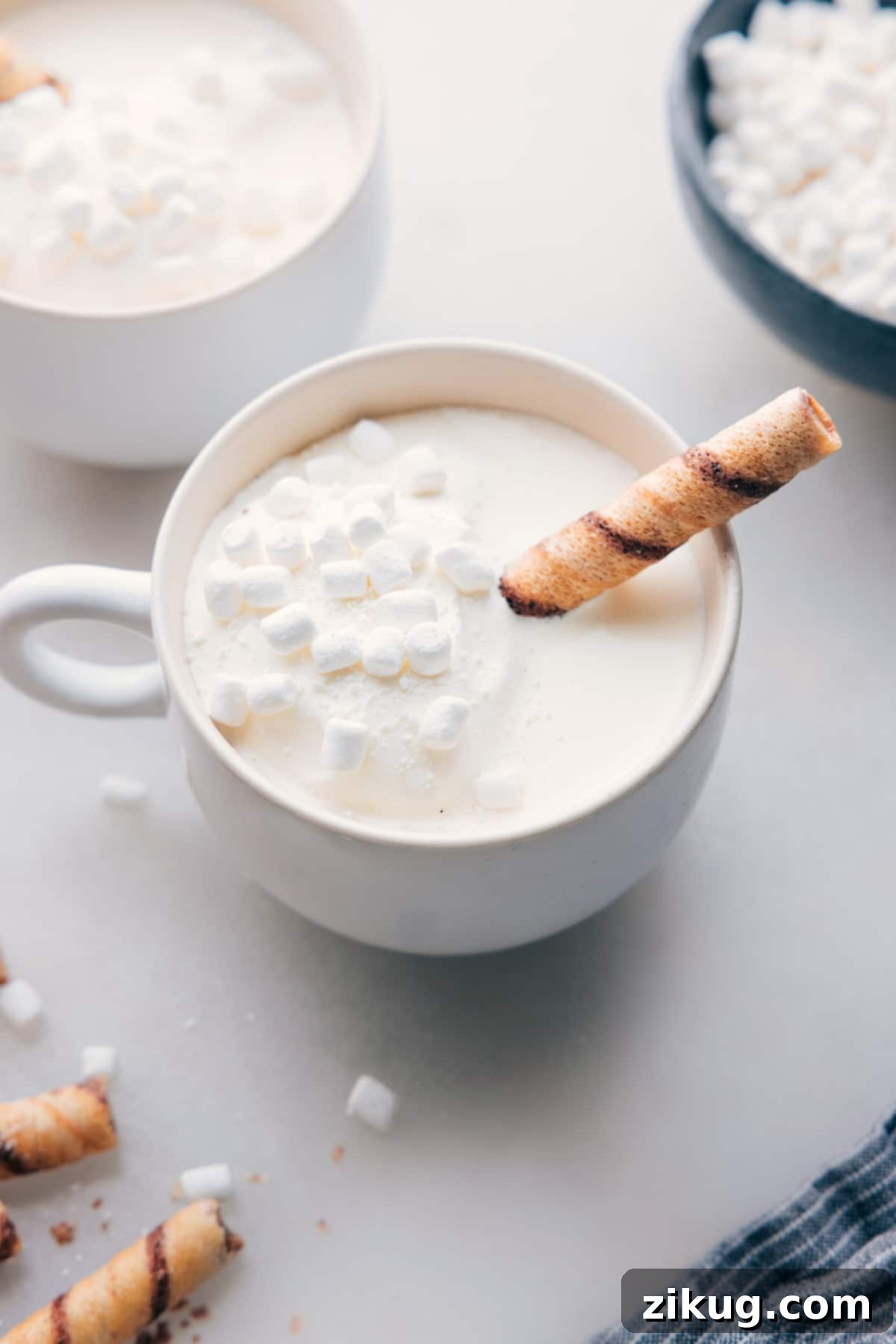 The finished White Hot Chocolate beverage in a beautiful mug, generously topped with fluffy mini marshmallows. The drink looks inviting and perfectly suited for enjoyment on a chilly day.