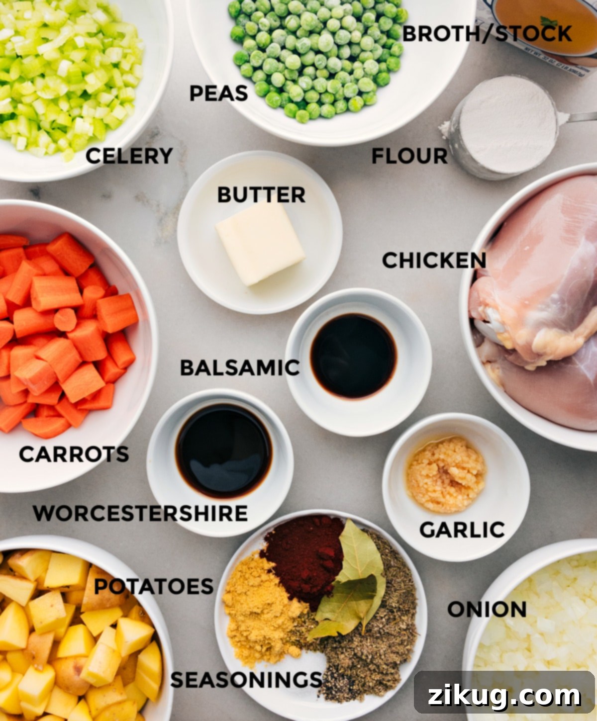 Essential Ingredients for a Flavorful Chicken Stew A colorful array of fresh ingredients for Crockpot Chicken Stew laid out on a tray, including chicken thighs, carrots, onions, celery, potatoes, garlic, and various seasonings.