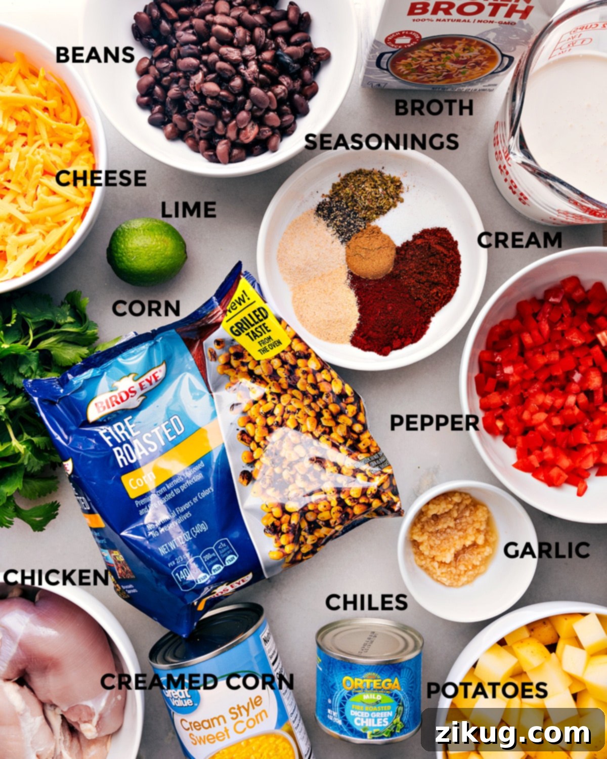 All the ingredients for the recipe including peppers, potatoes, chicken, spices, and other fresh produce, arranged neatly for preparation.