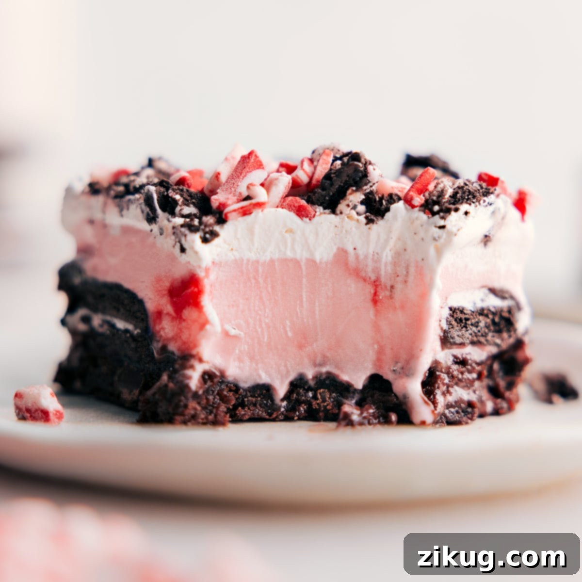 Peppermint Brownie Ice Cream Bar with a Bite Taken A close-up shot of a Peppermint Brownie Ice Cream Bar with a bite taken, revealing the satisfying layers of rich brownie, crisp Oreos, smooth fudge, creamy peppermint ice cream, and fluffy whipped cream, topped with peppermint crunch, emphasizing its delicious appeal and complementary textures.