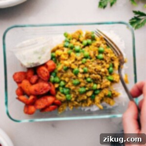 Flavorful Indian Ground Turkey Meal Prep Bowls 2 A vibrant meal-prepped container featuring fluffy rice, savory Indian ground turkey, roasted vegetables, and a separate portion of cooling cucumber yogurt sauce, perfect for a quick and satisfying lunch or dinner.