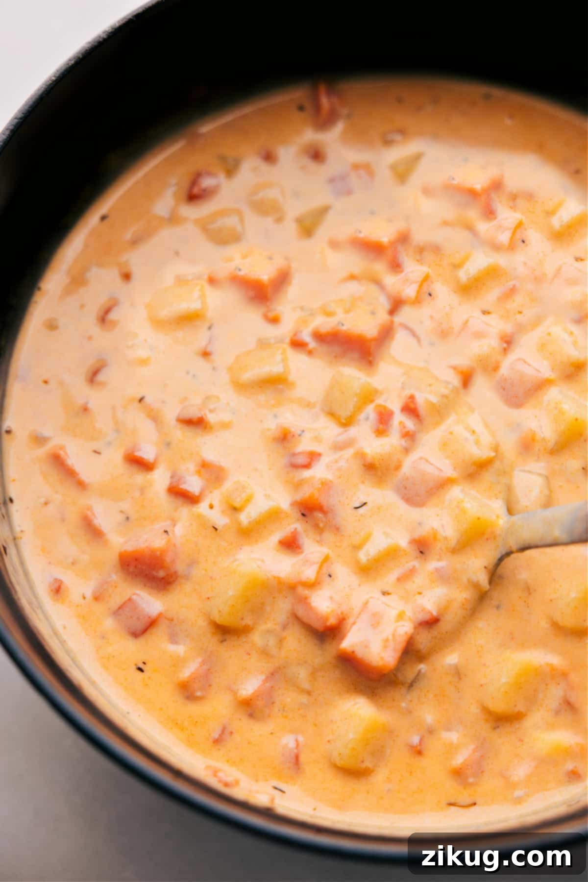 Cheesy Potato Soup — a bowl of pure comfort and flavor. Overhead photo of a steaming bowl of Cheesy Potato Soup, garnished with crispy bacon and fresh herbs, inviting warmth and comfort.