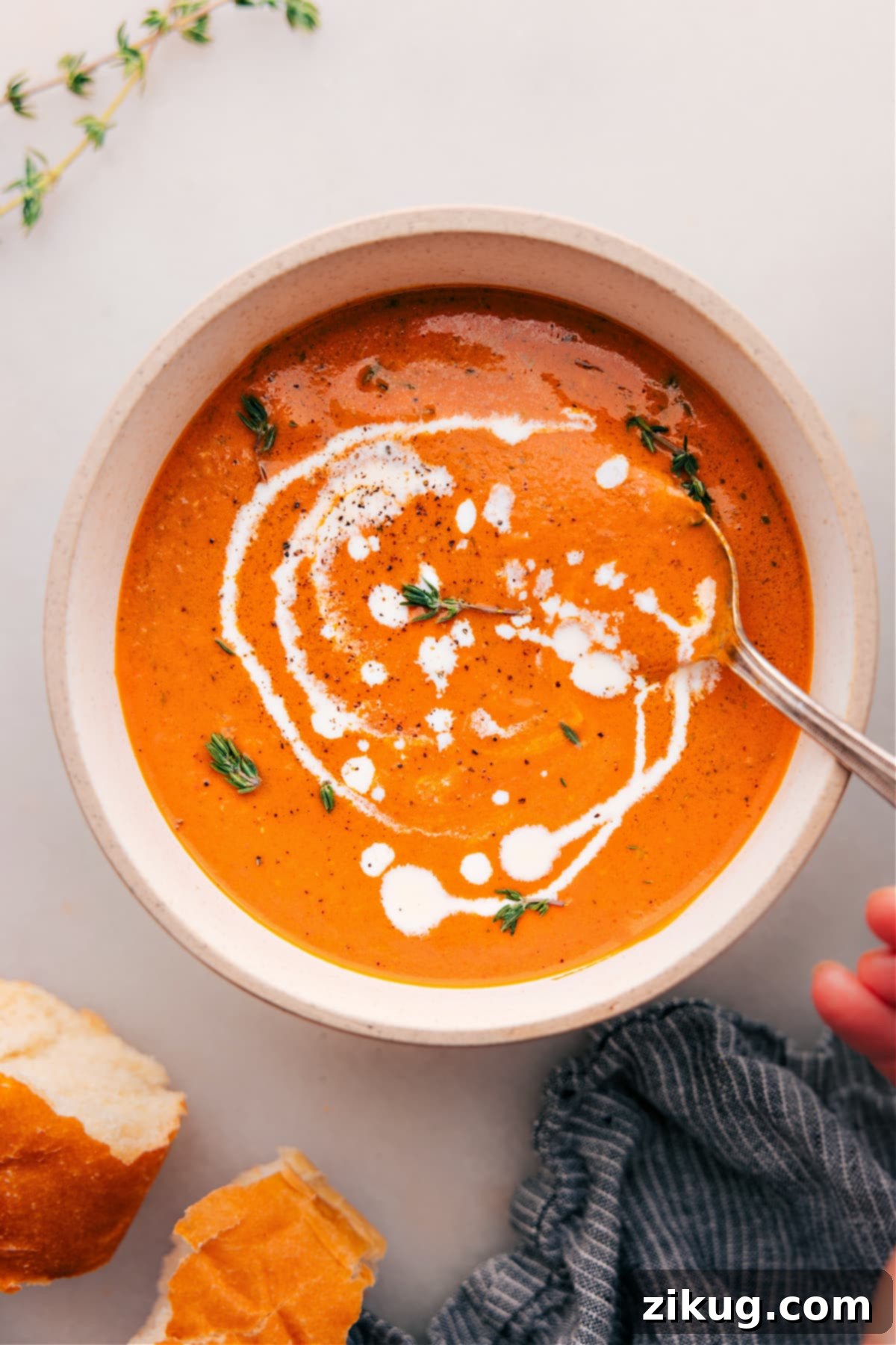 Big bowl of Roasted Red Pepper Soup, garnished with fresh basil and a swirl of pesto