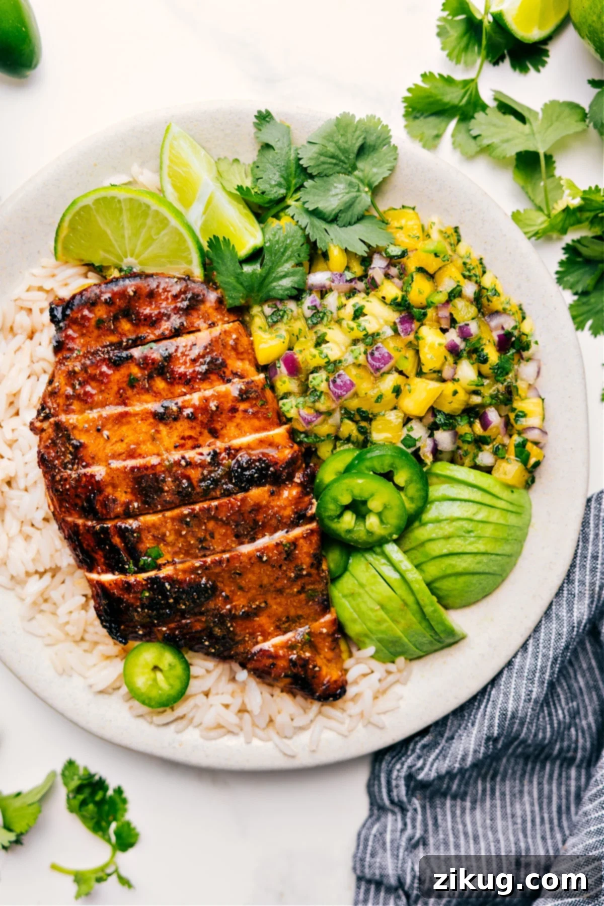 The Best Pineapple Chicken and Rice Recipe Grilled Pineapple Chicken served over fluffy rice, garnished with fresh pineapple salsa, creamy avocado slices, and a touch of spicy jalapeño.