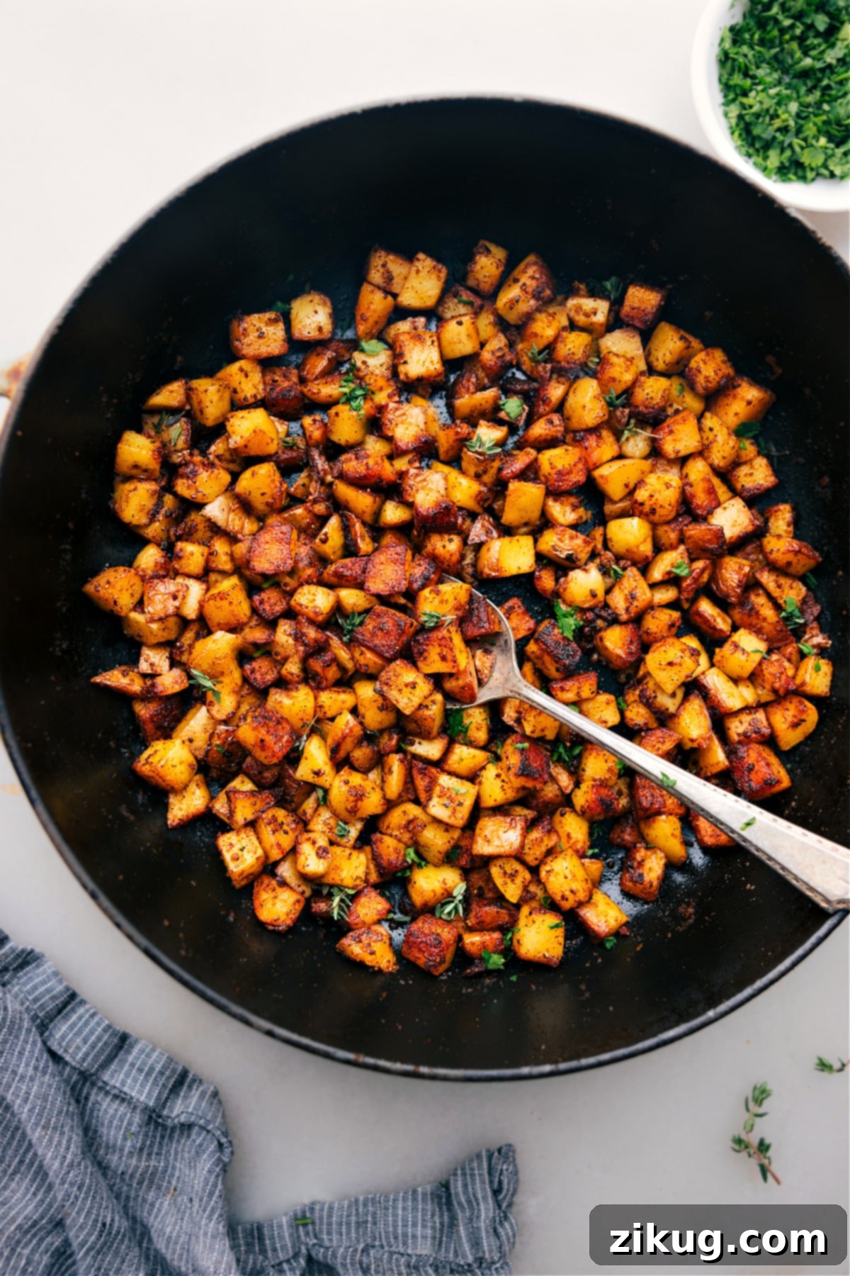 Skillet Breakfast Potatoes Freshly cooked Skillet Breakfast Potatoes ready to be enjoyed, garnished with fresh herbs in a serving bowl.
