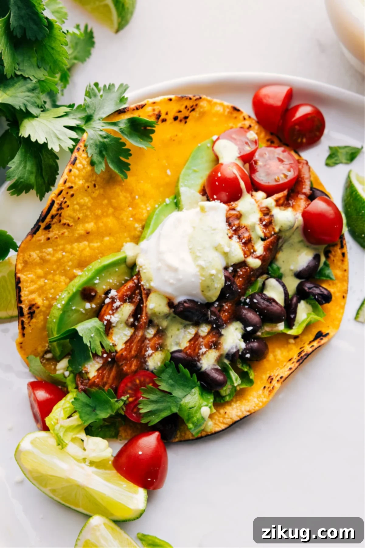 A vibrant platter of fully assembled Crockpot Shredded Chicken Tacos, garnished with fresh cilantro and lime wedges, ready to be served and enjoyed.
