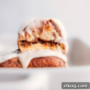 Hawaiian Roll Cinnamon Rolls stacked on top of each other, topped with cream cheese glaze.