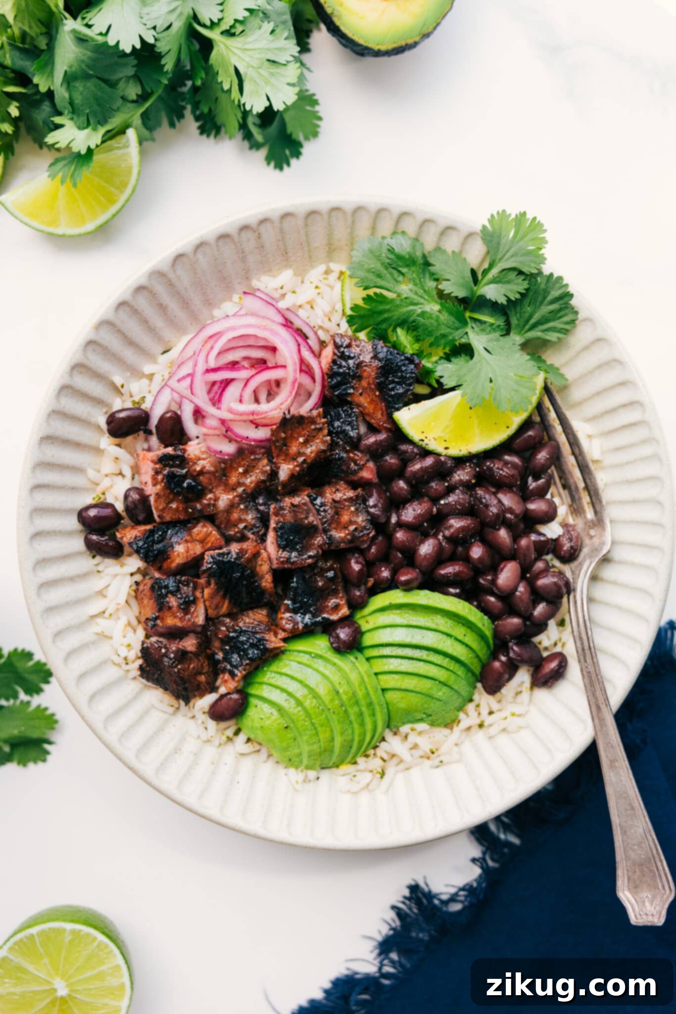 The Ultimate Meal Prep: Steak Bowls Steak bowl with rice, black beans, avocado, pickled onions, cilantro, and lime, showcasing a vibrant and healthy meal.