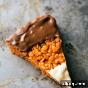 Close-up of a finished Candy Corn Krispie Treat, showing the distinct white, orange, and chocolate layers.