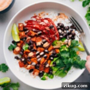 Hearty Sweet Potato Black Bean Power Bowls 2 Sweet Potato & Black Bean Burrito Bowls with dressing drizzled over it.
