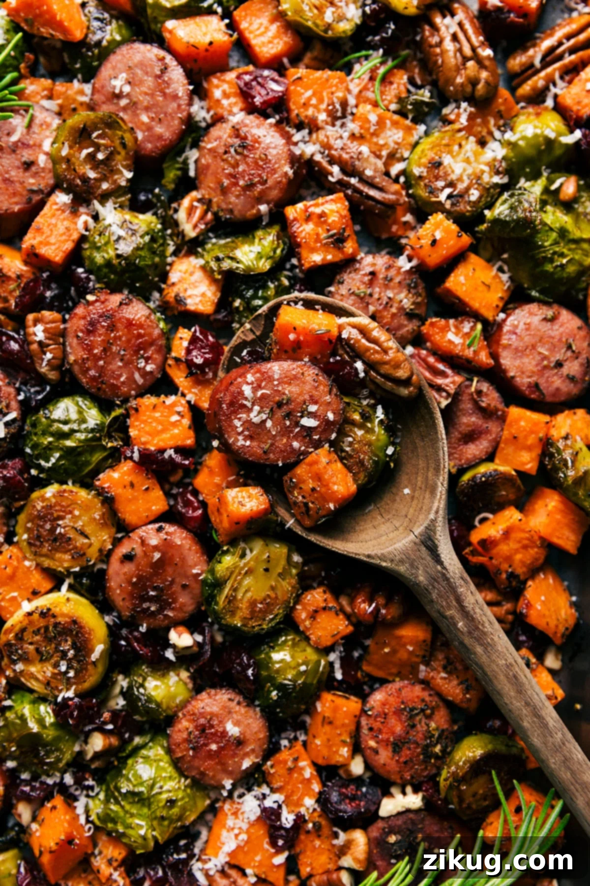 Delicious One-Pan Harvest Vegetables and Sausage Dinner Roasted harvest vegetables and sausage on a sheet pan with cranberries and pecans.