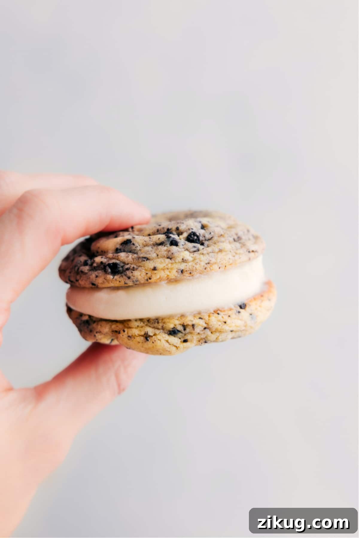 The Best Oreo Whoopie Pies with Cream Cheese Frosting A beautifully assembled Oreo Whoopie Pie held up, showing its thick, soft cookie layers and generous, creamy filling.