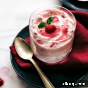 A close-up shot of the finished Raspberry Fluff dessert, showing its creamy texture and raspberry chunks.