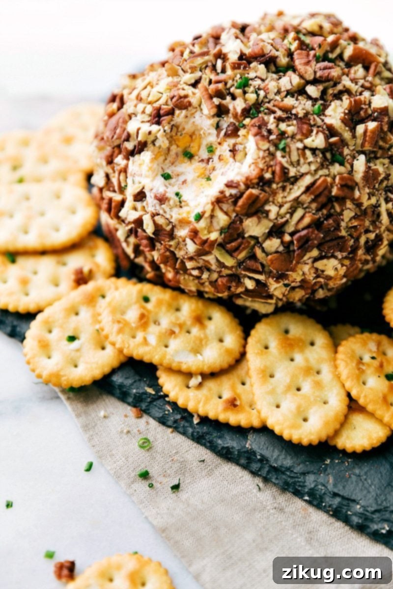Gorgeous Savory Cheese Ball with Crackers - Ready to Enjoy as a Delicious Snack A gorgeous cheese ball with crackers on the side, and a bite scooped out of it, ready to be enjoyed as both a delicious and visually appealing snack. Perfect for holiday entertaining.