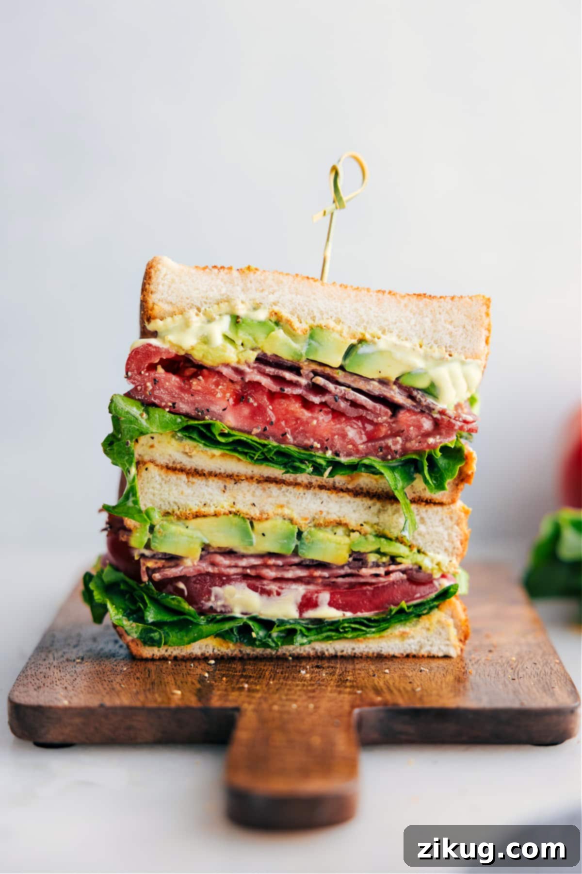 BLT Sandwich cut in half and stacked on top of each other, showcasing perfectly layered ingredients.