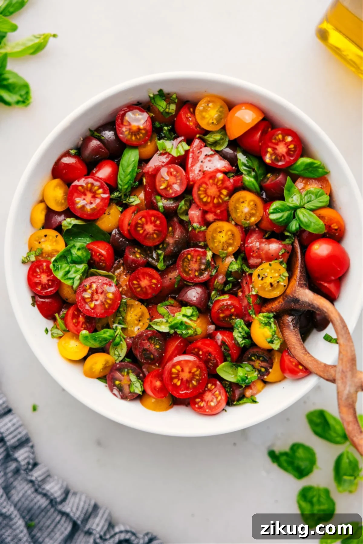 Vibrant tomato salad in a stylish bowl, garnished with fresh basil leaves, ready to be served.