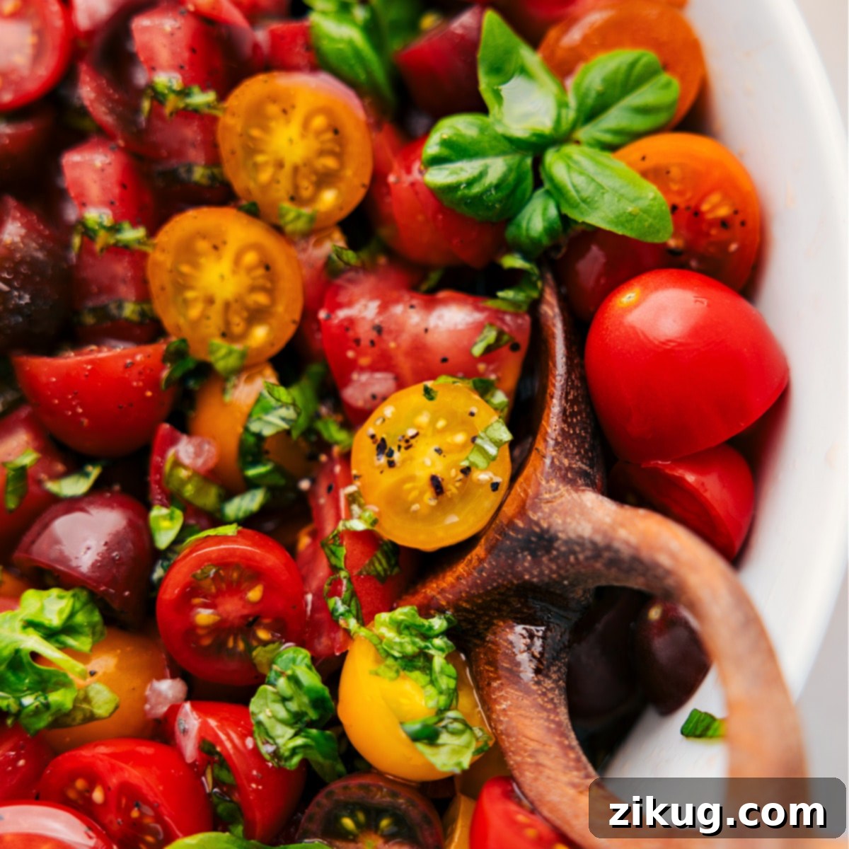 The finished fresh tomato salad, perfectly tossed and presented in a serving bowl, ready to be enjoyed.