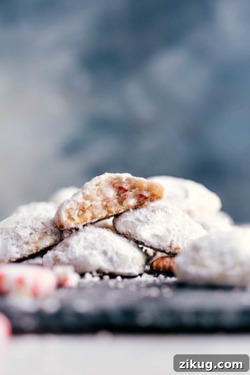 Finished Peppermint Snowball Cookies, Flavor-Packed and Delicious, with a Bite Revealing Delightful Interior Finished snowball cookies with peppermint, delicious and flavor-packed, with a bite taken out to reveal the delightful interior.
