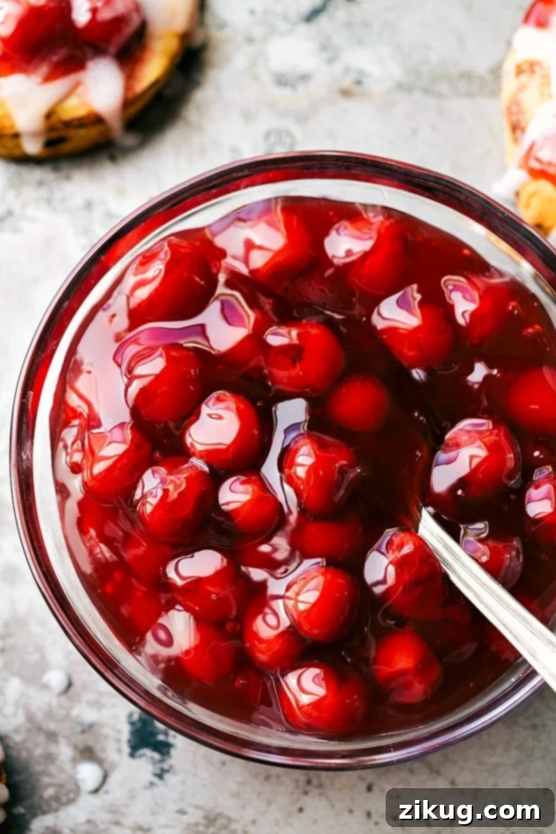 A close-up view of an open can of bright red cherry pie filling, showcasing the whole cherries and sweet glaze, ready for baking.