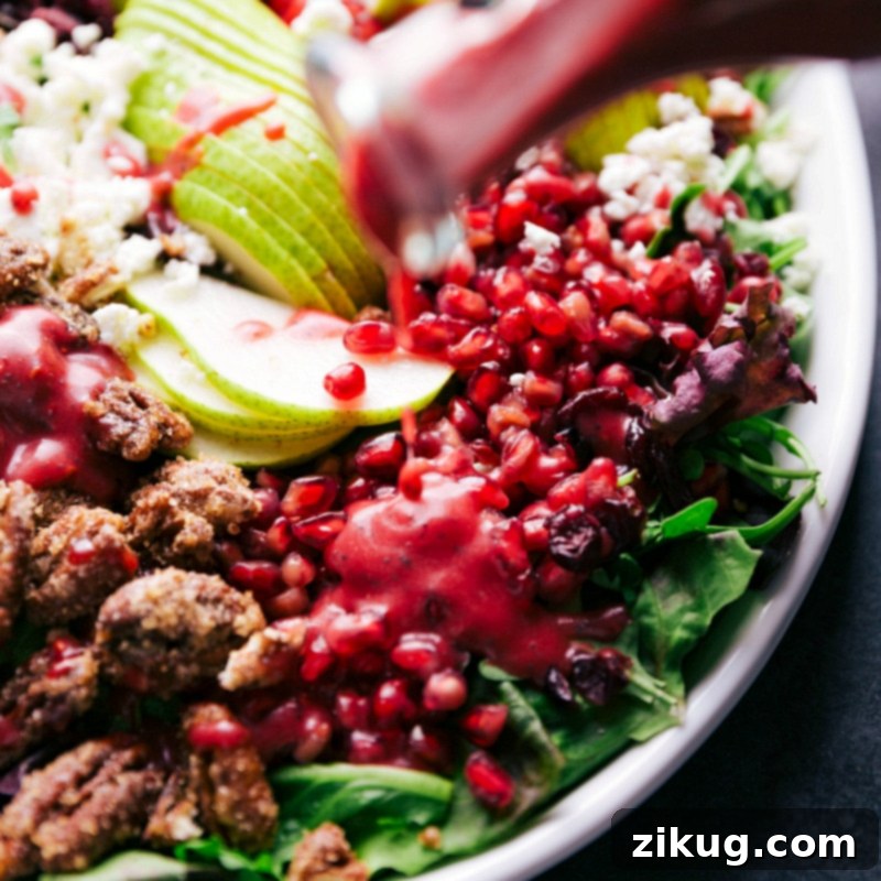 Dressing Pomegranate Arils: The First Step to a Flavorful Salad A stream of rich, emulsified dressing cascades over a bed of vibrant pomegranate arils, ready to be integrated into a fresh, wholesome salad.
