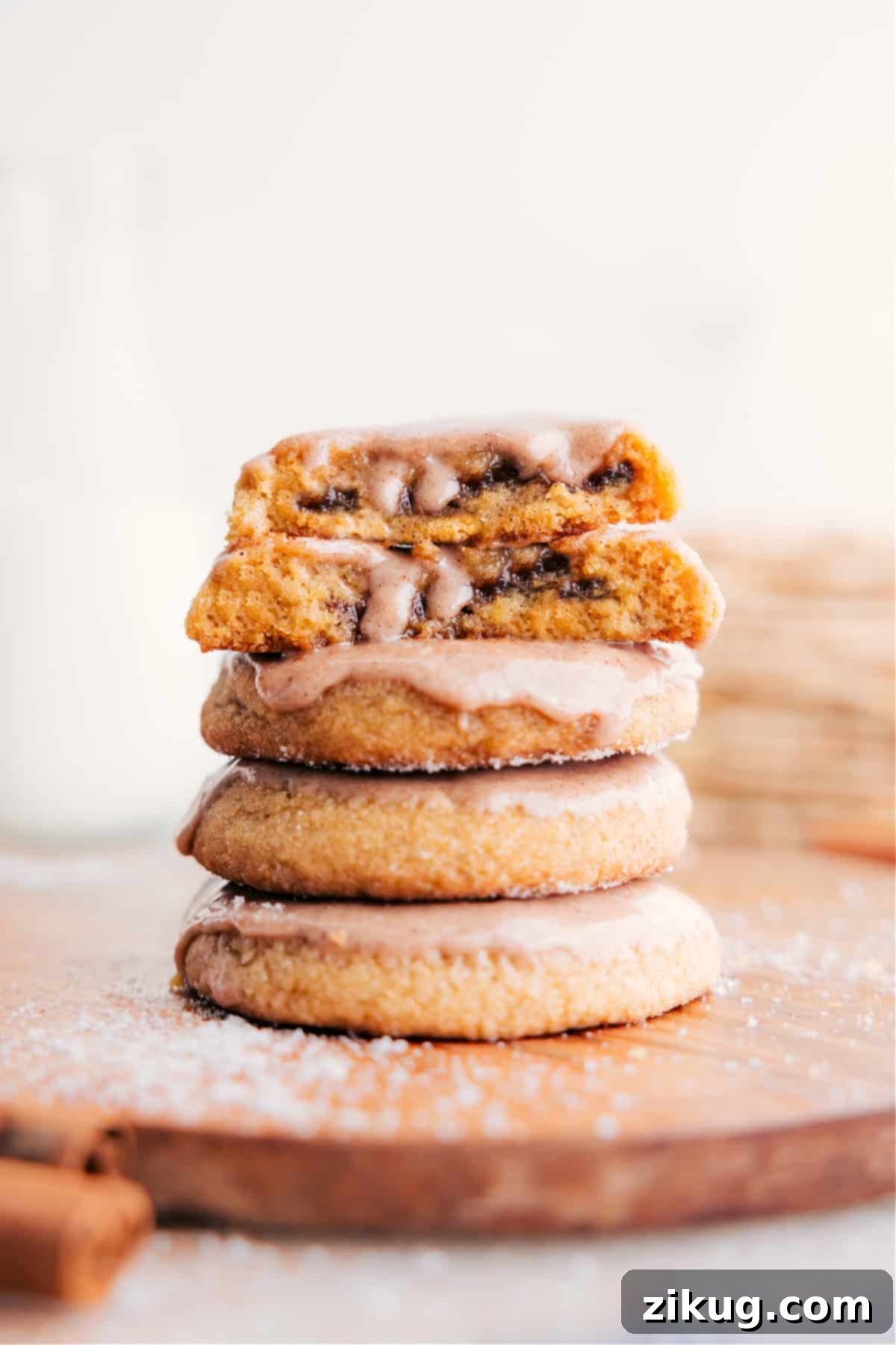 The Best Homemade Pop-Tart Cookies Recipe with Cinnamon Glaze A stack of golden brown sugar Pop-Tart cookies, with one cut in half to show the rich cinnamon-sugar filling inside.