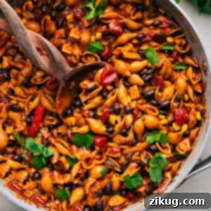 Enchilada Pasta in a red skillet with a spoon