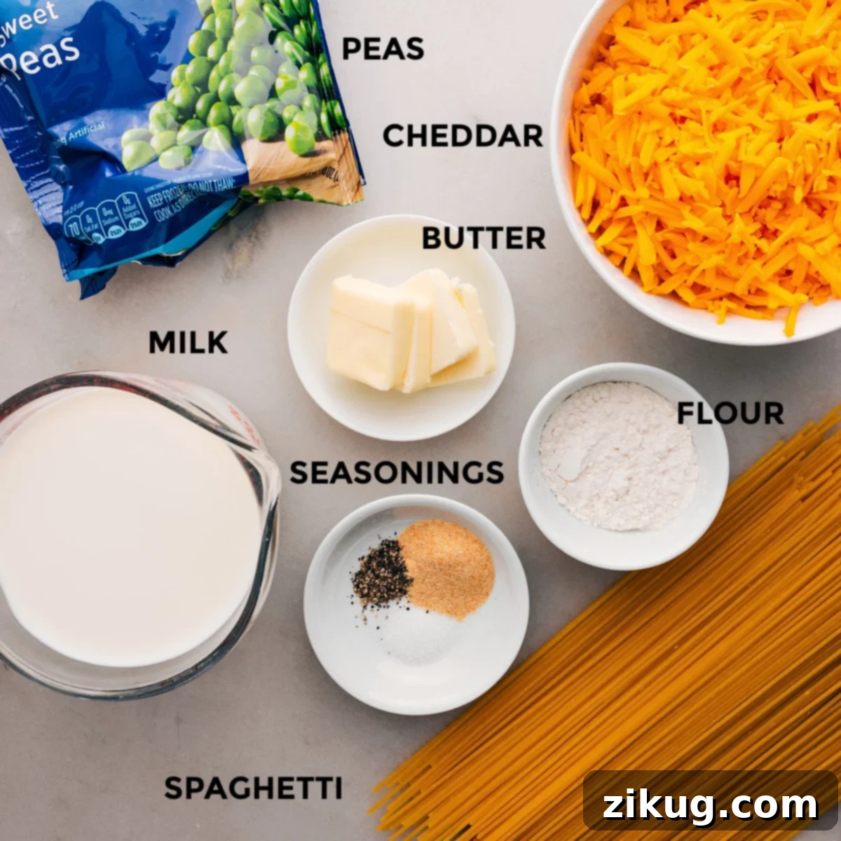 This recipe's ingredients are prepped for easy assembly: pasta, flour, cheese, butter, peas, and milk.