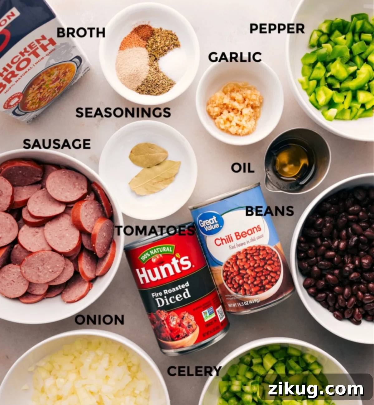Ingredients For Black Beans And Sausage Over Rice Dish All essential ingredients for slow cooker black beans and sausage laid out: smoked sausage, various beans, diced vegetables, broth, and seasonings.