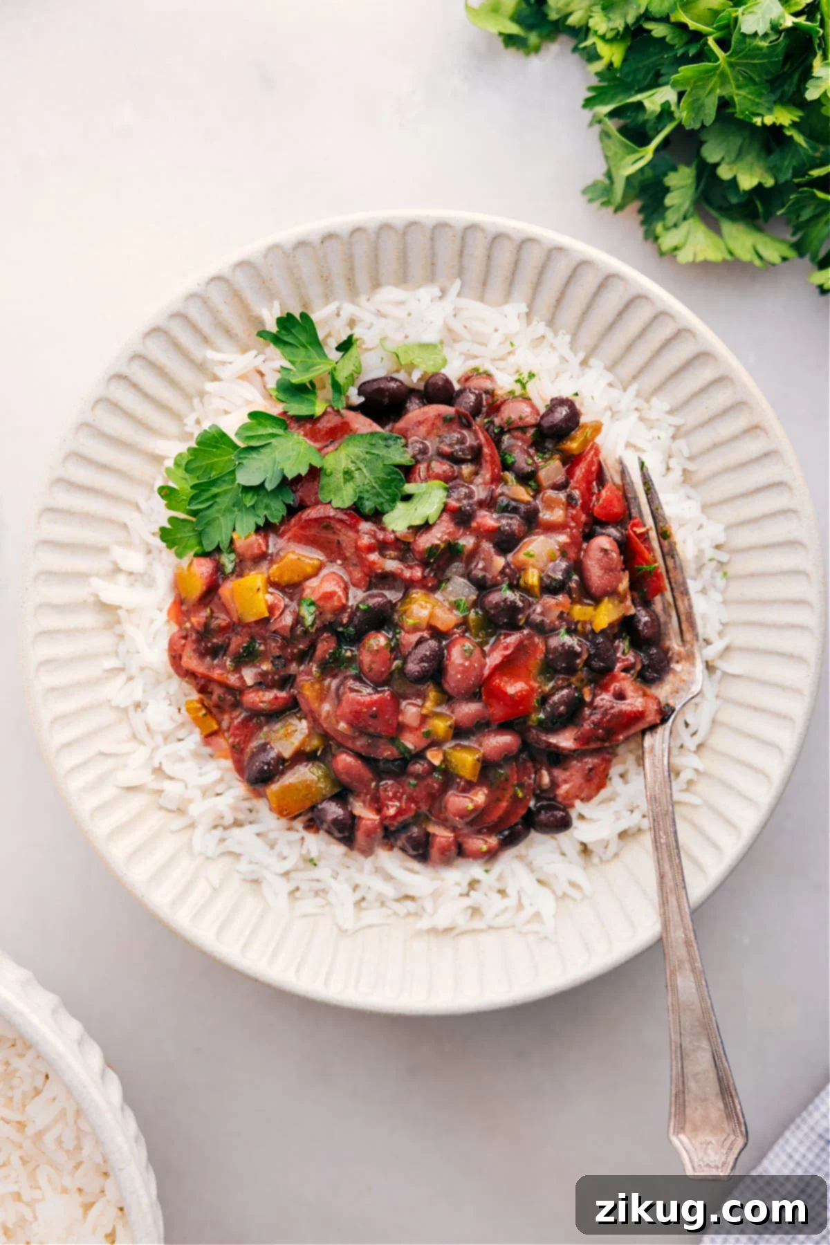 Serve Slow Cooked Black Beans And Sausage Over Rice Hearty black beans and sausage served over fluffy white rice with fresh herbs.