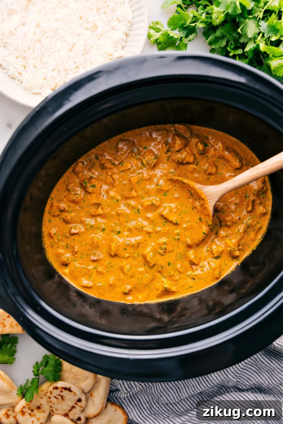 Crockpot Butter Chicken cooks in the slow cooker and is perfect for serving over a bed of rice, showcasing a creamy, rich sauce and tender chicken pieces.