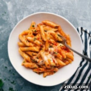 Crimson and Cream Pasta 4 Warm and delicious red and white pasta in a bowl, complete with a fork and topped with freshly shredded cheese.