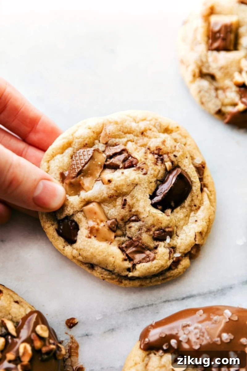 Freshly baked toffee cookies held in hand, still warm and ready to be savored.
