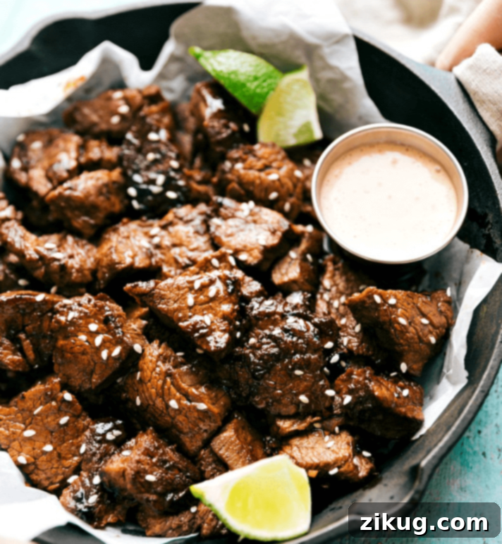 Easy Asian Steak Bites are so delicious--nobody would guess how easy they are to make! A plate full of savory Asian Steak Bites, perfectly seared and garnished with sesame seeds, ready to be enjoyed.